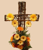 Linda cruz hecha con flores gerberas de varios colores.