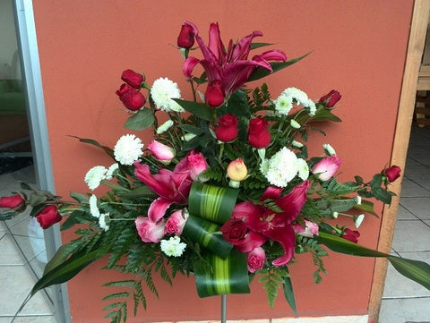 Palmatoria hecha con rosas rojas y flores blancas