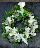 Corona fúnebre con rosas y flores blancas artificiales.