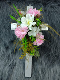 Preciosa cruz de madera con flores artificiales blancas, rosadas y hojas verdes