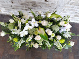 Palmatoria premium, hecha con flores naturales blancas y follaje verde.