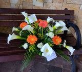 Linda palmatoria hecha con flores blancas, anaranjadas y follajes verdes.