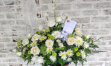 Linda y grande Palmatoria hecha con rosas blancas y variedad de follaje verde.