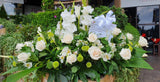 Palmatoria grande elaborada con flores blancas y follaje verde